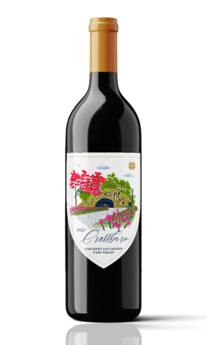 Crossbarn Cabernet Sauvignon Napa Valley 2021 wine bottle. The label features an illustration of the iconic stone arch bridge at the University of Notre Dame, framed by pink tulips and a vibrant red tree.